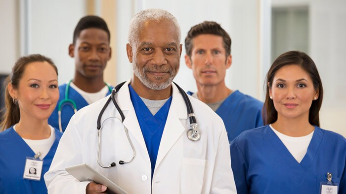 Several doctors look at camera with smiles on their faces